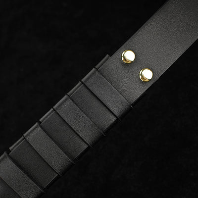 Black leather belt with gold metal loops on a black background