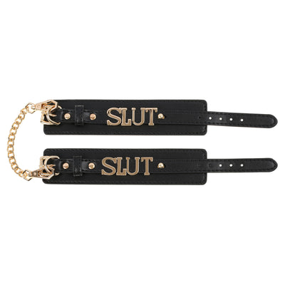 Two black leather straps with gold 'SLUT' text on a white background
