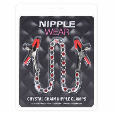 Nipple Wear crystal chain nipple clamps in a blister pack. The product consists of two silver silicone-coated alligator-style clamps with red silicone tips, connected by a silver chain studded with clear crystals.