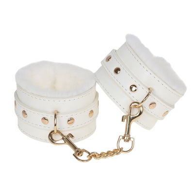 White leather cuffs with gold chain on a white background