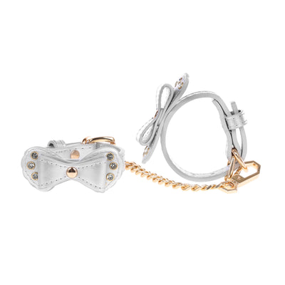 Pair of silver bow-shaped cuffs with gold accents on a white background