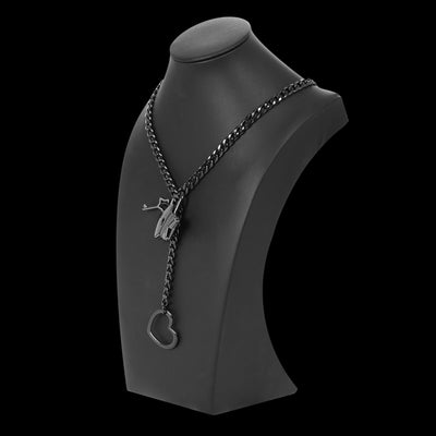 Black chain necklace with heart pendant on a black mannequin bust against a white background