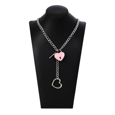 Necklace with heart-shaped lock and key pendants on a black mannequin bust.