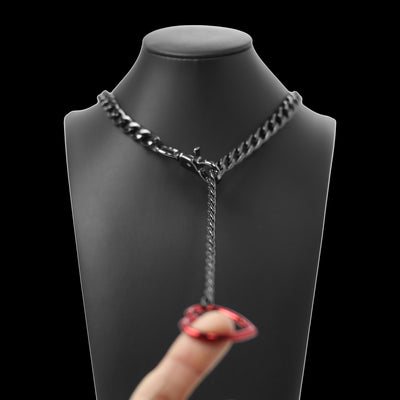 Black chain necklace on a mannequin with a hand holding a red and black ring.
