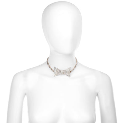 A gold-toned rhinestone choker necklace with a bow-shaped center, displayed on a white mannequin torso against a plain white background.
