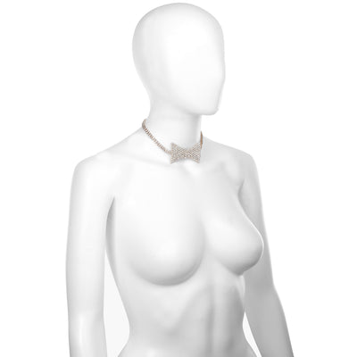 A white mannequin torso wearing a sparkling gold-toned choker necklace with a bow-shaped center, shown against a plain white background.